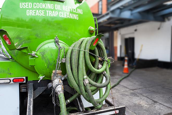 a service truck pumping grease from a restaurant's grease trap in East Northport